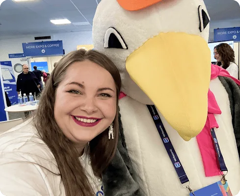 Membre de l’équipe Collaborator posant avec la mascotte mouette de BrightonSEO lors de l’événement de 2025.