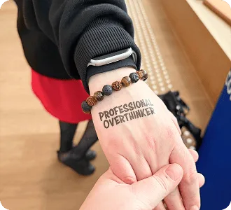 Tatouage temporaire « Professional Overthinker » sur la main d’un participant au Baltic-Nordic SEO Summit 2026.