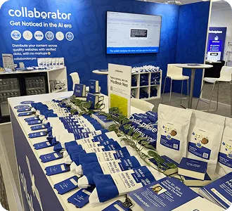 Stand de Collaborator au BrightonSEO 2026, avec des articles promotionnels, des brochures et un écran de présentation.
