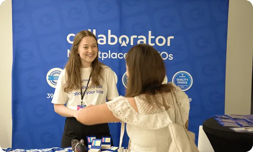 Représentant de Collaborator échangeant avec un participant sur le stand du Croatia SEO Summit.
