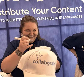 Membre de l’équipe Collaborator personnalisant une casquette de la marque sur le stand lors du SEO Mastery Summit 2025.